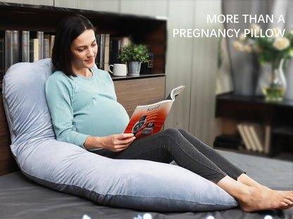 Pregnant woman sitting up in bed reading with the pregnancy pillow supporting her whole back